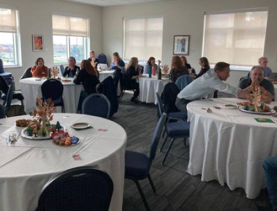 Colleagues sitting at tables during the first world cafe on the Roots of Belonging